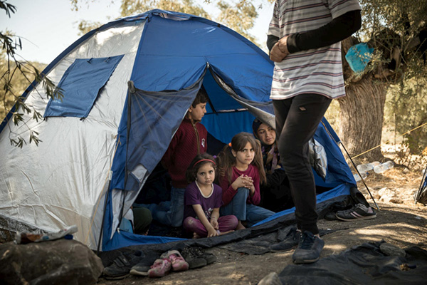 A Syrian family from Idlib recently arrived on the Greek island of Lesvos and living in an olive grove next to Moria reception centre. (Photo: UNHCR/Gordon Welters)