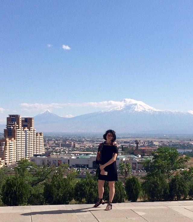 Arev Dinkjian stands at Tsitsernakaberd with Ararat at her back in Yerevan, Armenia, 2016