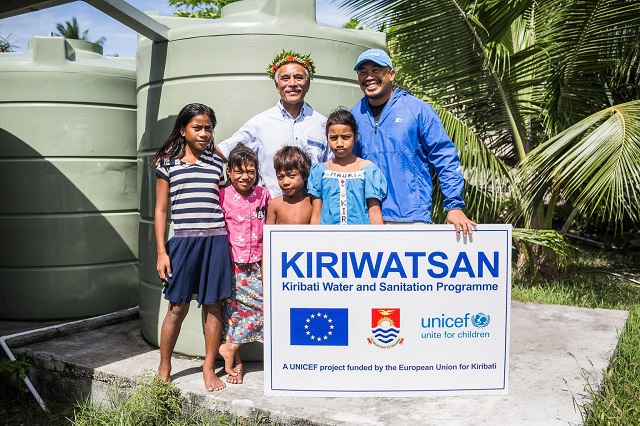 Kiribati's former President Anote Tong, former UNICEF Country Director Cromwell Bacareza, and children from Abaiang Atoll taking a group photo in front of water tanks installed in Abaiang as a part of UNICEF-EU supported Kiribati Water and Sanitation program KIRIWATSAN, at Betio town, South Tarawa, Kiribati