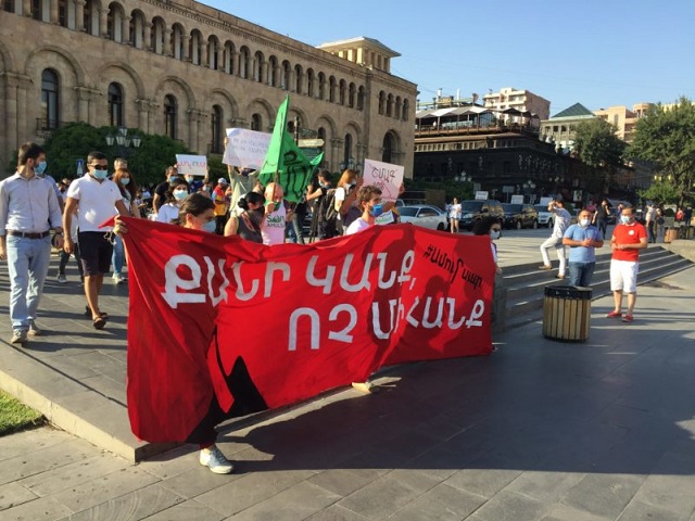 The bright red banner held up at Republic Square in Yerevan reads “As long as we exist, not one mine” (photo Mateos Hayes)