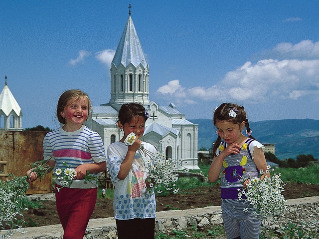 Girls gathering flowers near the church yard of Ghazenchetsots Cathedral in Shushi. Photo (c) 2020 Robert Kurkjian