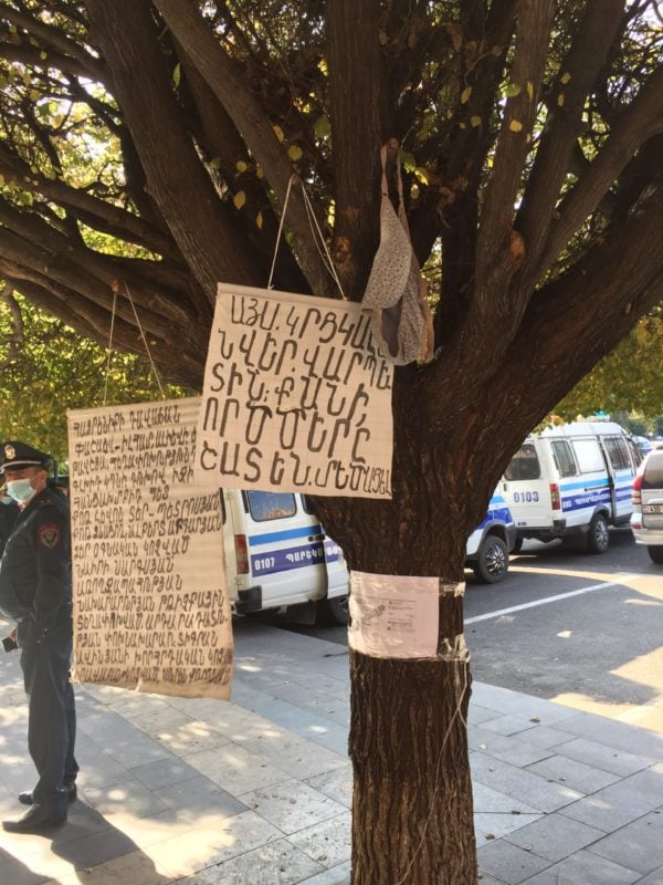A bra hangs from a tree along with a sign with an emasculating message on it directed towards Nikol Pashinyan